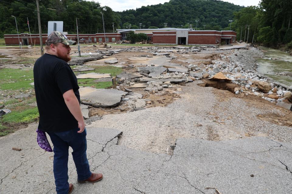 Jalen Cooper, 27, a teacher in Buckhorn, Ky., surveys flooding damage to a community school.