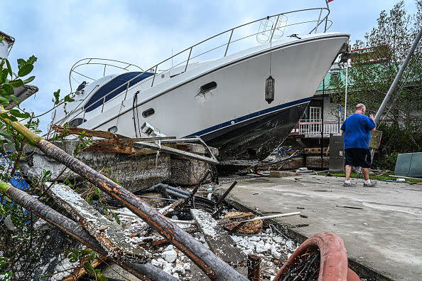 A boat is left stranded on the shore in the aftermath of Hurricane Ian in Fort Myers, Florida, on September 29, 2022. - Hurricane Ian left much of coastal southwest Florida in darkness early on Thursday, bringing 