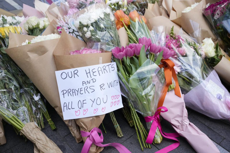 A note is left with flower tributes near a crime scene at Bondi Junction in Sydney, Sunday, April 14, 2024, after several people were stabbed to death at a shopping center Saturday. Police have identified Joel Cauchi, 40, as the assailant that stabbed several people to death at a busy Sydney shopping center Saturday before he was fatally shot by a police officer. (AP Photo/Rick Rycroft)