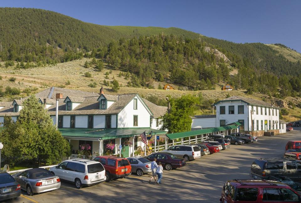 a parking lot with cars and a hill in the background