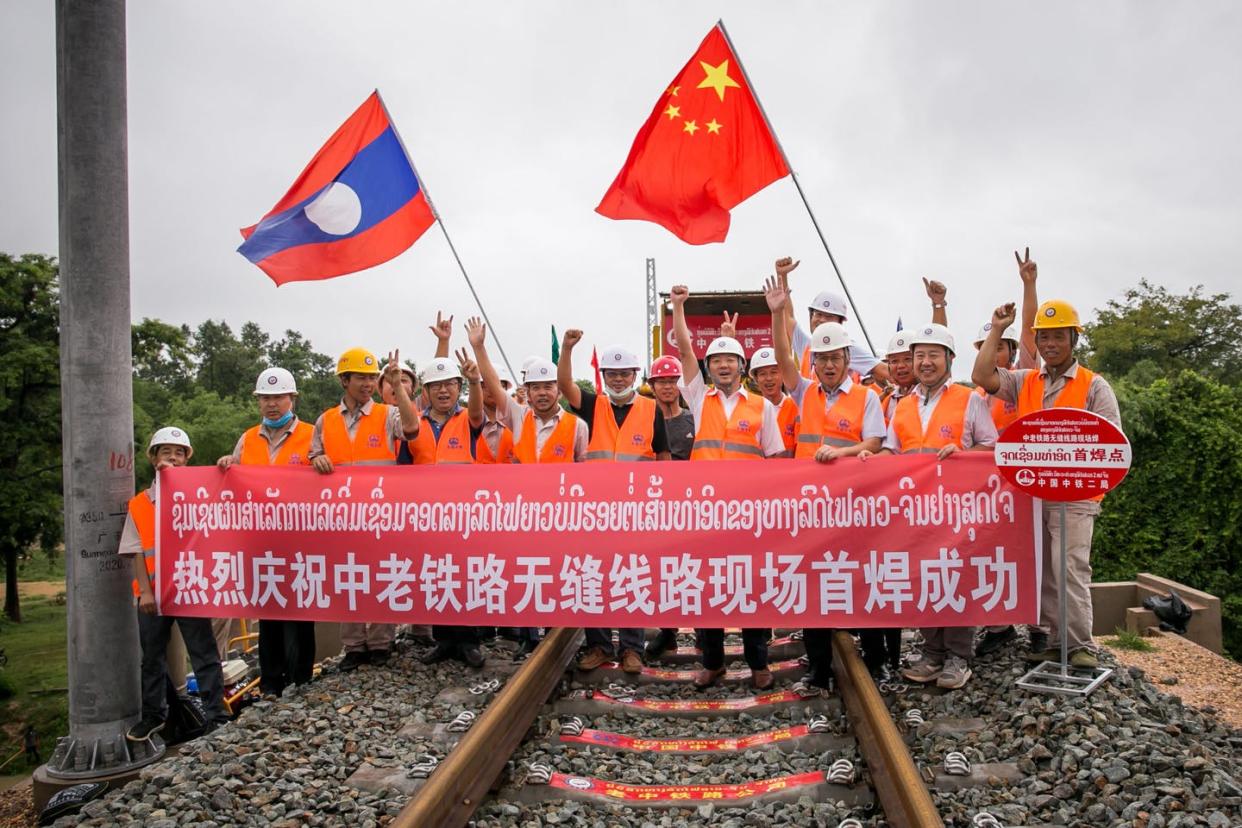 <span class="caption">Chinese engineers pose after welding the first seamless rails for the China-Laos railway in Vientiane, Laos, June 18, 2020.</span> <span class="attribution"><a class="link " href="https://www.gettyimages.com/detail/news-photo/june-18-2020-workers-from-china-railway-no-2-engineering-news-photo/1221809225" rel="nofollow noopener" target="_blank" data-ylk="slk:Kaikeo Saiyasane/Xinhua via Getty Images;elm:context_link;itc:0;sec:content-canvas">Kaikeo Saiyasane/Xinhua via Getty Images</a></span>