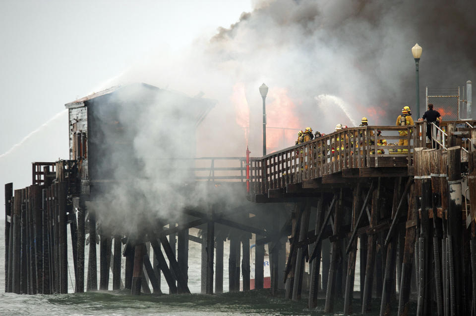 <p>Firefighters contend with a fire burning on the Seal Beach pier in Seal Beach, Calif. on May 20, 2016. The blaze erupted early Friday at the end of the long wooden pier southeast of Los Angeles. . Smoke was pouring out of holes in the roof, much of which had collapsed. The restaurant has been closed since 2013. (Ken Steinhardt/The Orange County Register via AP) </p>