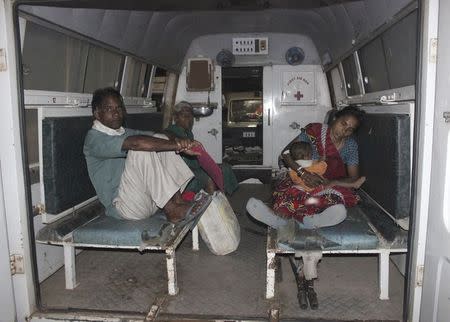 A woman (R), who underwent a botched sterilization surgery at a government mass sterilization "camp", feeds her baby as she sits inside an ambulance while being moved to Chhattisgarh Institute of Medical Sciences (CIMS) hospital from a district hospital in Bilaspur, in Chhattisgarh, November 10, 2014. REUTERS/Stringer