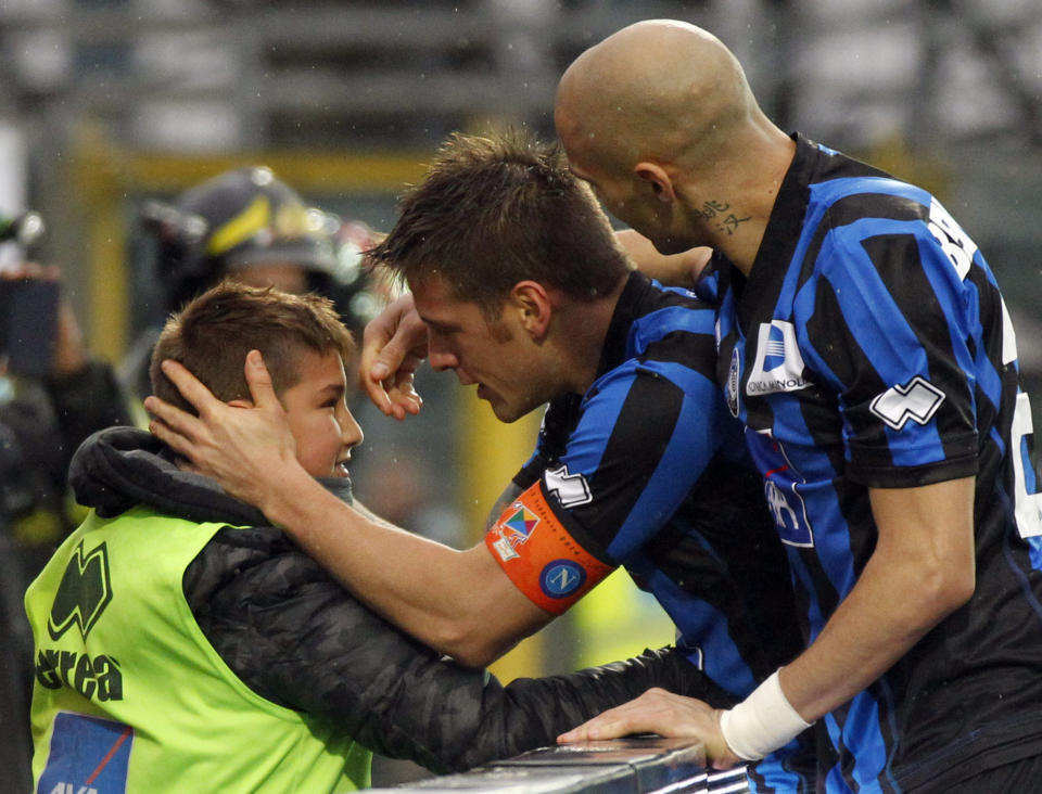 Atalanta's German Denis, center, of Argentina, celebrates with his son Matias after scoring during a Serie A soccer match against Napoli in Bergamo, Italy, Sunday, Feb. 2, 2014. (AP Photo/Felice Calabro')