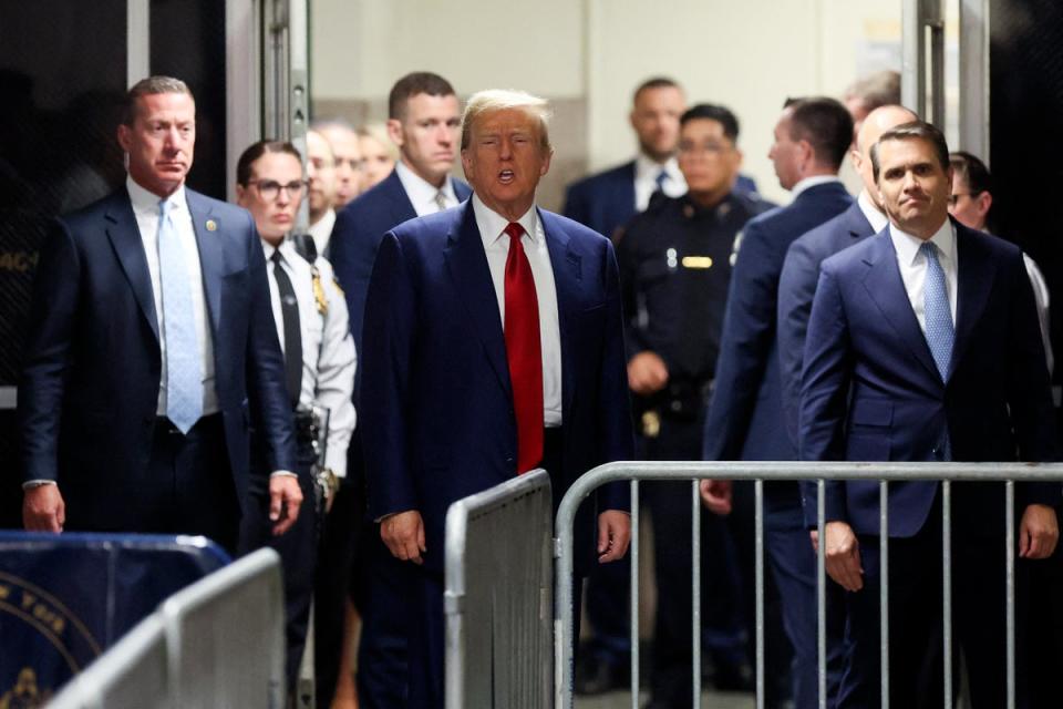 Donald Trump speaks to reporters outside a criminal courtroom doors in Manhattan on 25 March. (POOL/AFP via Getty Images)