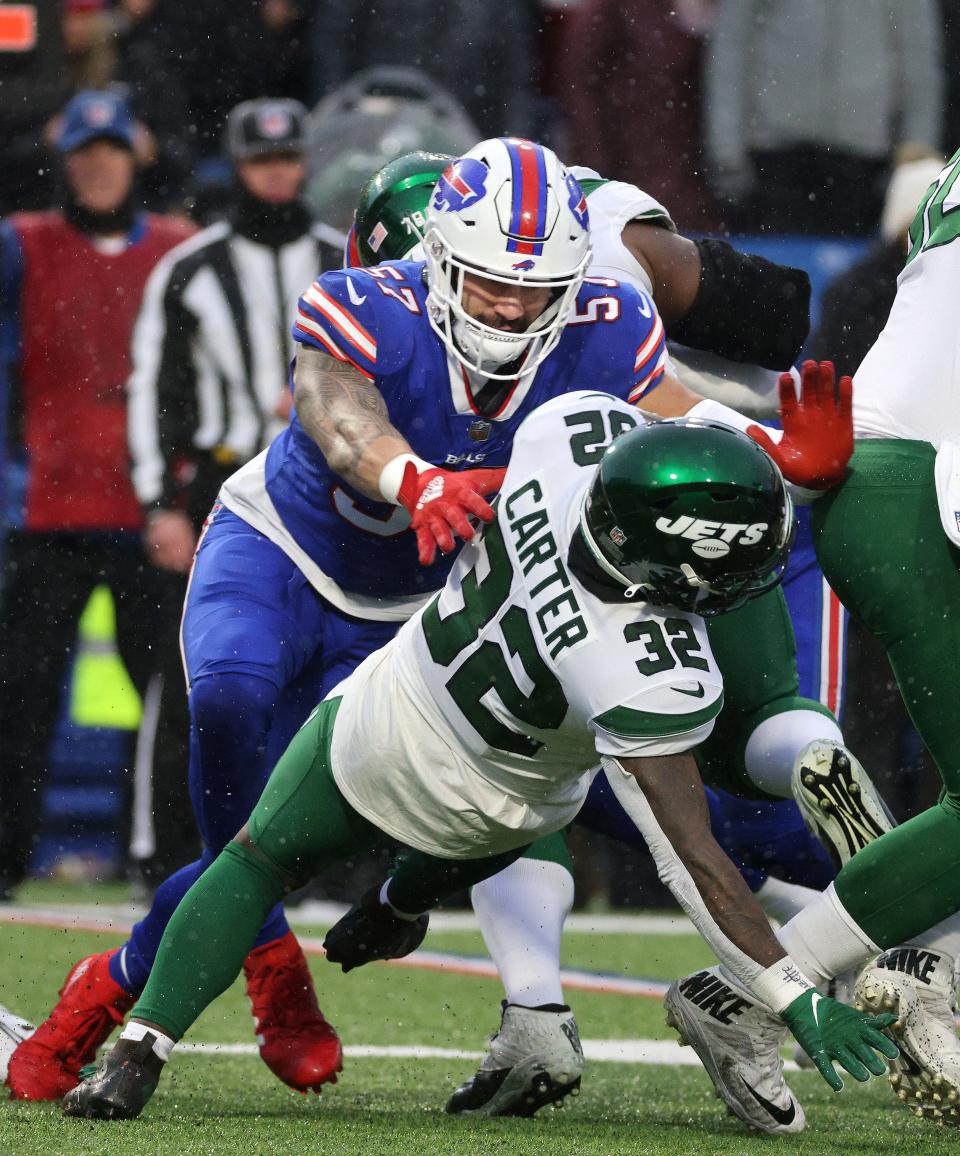 Jets running back Michael Carter its tackled behind the line of scrimmage by Buffalo’s A.J. Klein. 