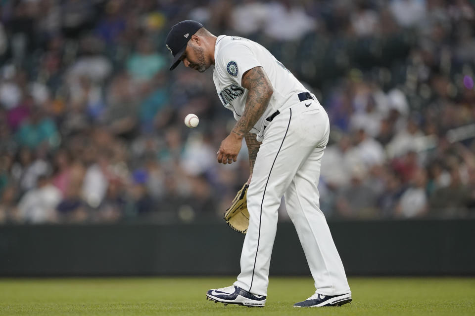 Seattle Mariners pitcher Hector Santiago tosses the baseball while returning to the mound during the fifth inning of the team's baseball game against the Houston Astros, Tuesday, July 27, 2021, in Seattle. It was the first game back for Santiago after he served a 10-game suspension for violating MLB's rules for foreign substances. (AP Photo/Ted S. Warren)