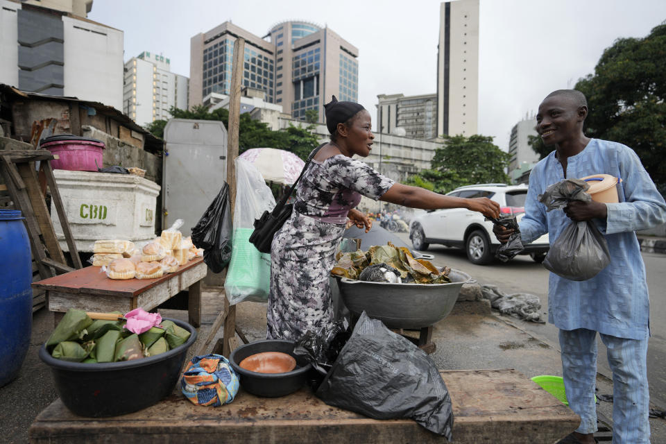 A woman sells boiled bean pudding made from a mixture of washed and peeled black-eyed beans, on the streets of Lagos, Nigeria, Tuesday Sept. 5, 2023. (AP Photo/Sunday Alamba)