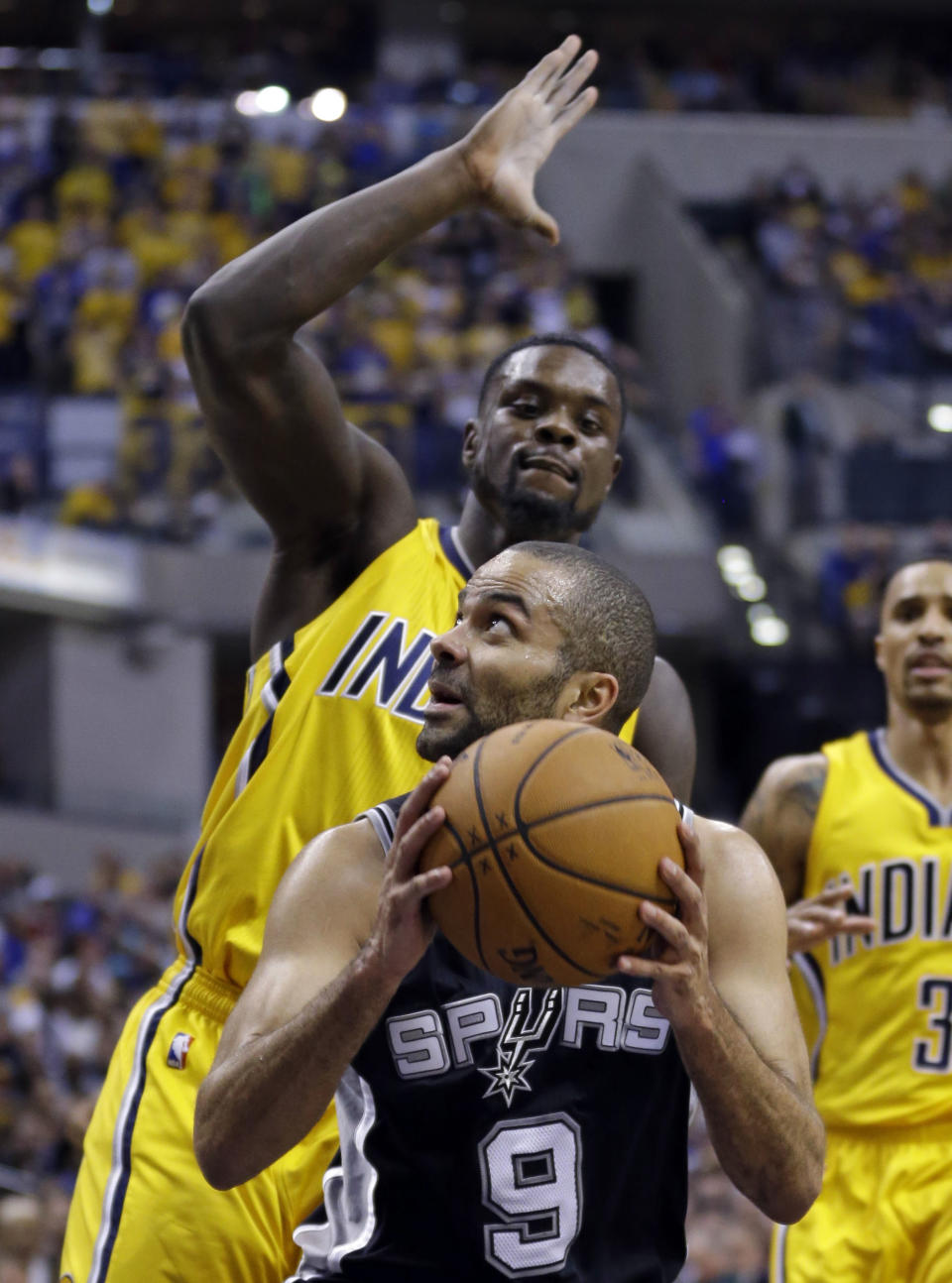 San Antonio Spurs guard Tony Parker (9) looks to shoot under Indiana Pacers guard Lance Stephenson in the second half of an NBA basketball game in Indianapolis, Monday, March 31, 2014. The Spurs defeated the Pacers 103-77. (AP Photo/Michael Conroy)