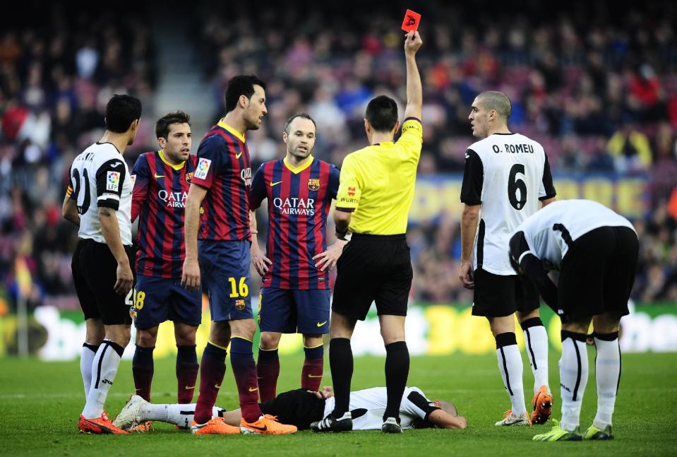 Referee shows a red card to FC Barcelona's Jordi Alba, second left, against Valencia during a Spanish La Liga soccer match at the Camp Nou stadium in Barcelona, Spain, Saturday, Feb. 1, 2014. (AP Photo/Manu Fernandez)