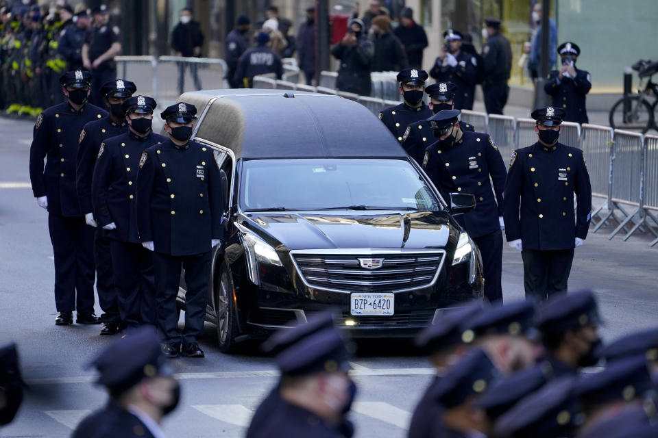 A hearse carrying the casket of New York City Police Officer Wilbert Mora arrives at St. Patrick's Cathedral for his wake, Tuesday, Feb. 1, 2022, in New York. Mora and Officer Jason Rivera were fatally wounded when a gunman ambushed them in an apartment as they responded to a family dispute. (AP Photo/John Minchillo)