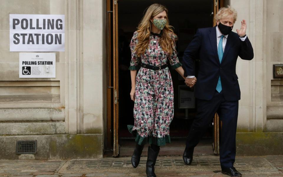 Boris Johnson leaves a polling station with his partner Carrie Symonds after casting his vote in local council elections in London - Matt Dunham/ AP 