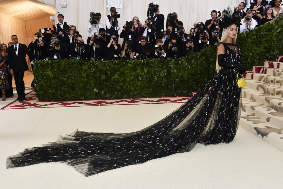 <p>Rita Ora embodied the Heavenly Bodies: Fashion & The Catholic Imagination theme when she showed up in this Prada black gown, speckled with pink and green detail. Photo: Getty Images </p>