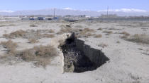 This frame grab from video taken on Jan. 8, 2019, shows fissure caused by drought and excessive water pumping in Malard, west of Tehran, Iran. Fissures appear along roads, while massive holes open up in the countryside, their gaping maws a visible sign from the air of something Iranian authorities now openly acknowledge: The area around the capital Tehran is literally sinking. (AP Photo)