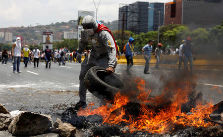 Manifestantes levantando una barricada en una calle en Caracas, abr 10, 2017. Miles de simpatizantes de la oposición venezolana volvieron el lunes a las calles del país petrolero para protestar contra el presidente Nicolás Maduro, al que acusan de haber desvirtuado su gobierno convirtiéndolo en una dictadura. REUTERS/Carlos Garcia Rawlins