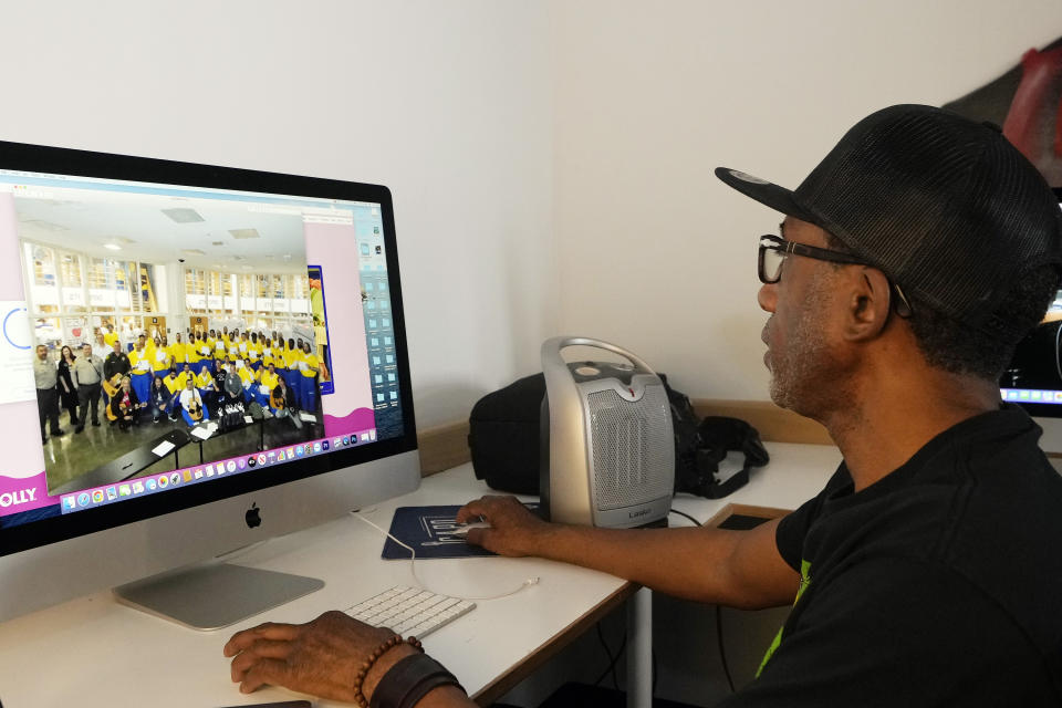 Francis Forde, facilities manager of Jail Guitar Doors USA, edits a file picture showing guitarist Wayne Kramer delivering guitars to inmates, in Los Angeles Friday, Feb. 9, 2024. Kramer recruited famous friends like Morello, Slash and Perry Farrell to perform concerts at prisons in California and his home state of Michigan, where he would leave behind guitars. Gradually he began spending one-one-one time with inmates, helping them craft their own songs. Jail Guitar Doors USA headquarters in Hollywood includes a recording studio and teaches multimedia production to young people recently released from custody. (AP Photo/Damian Dovarganes)