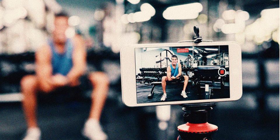 a phone on a tripod filming a man on a weights bench