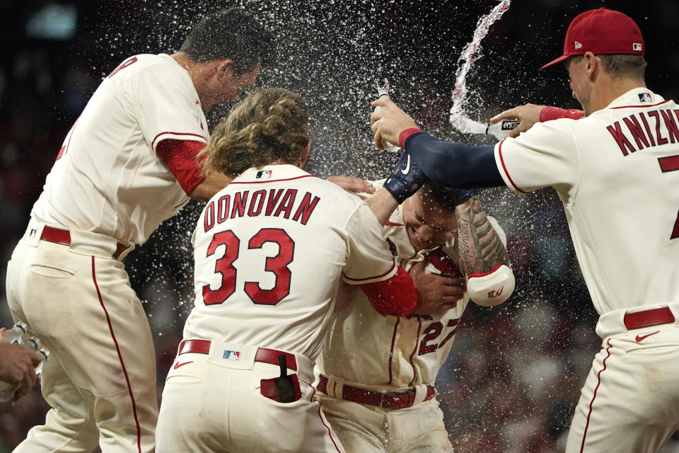 St. Louis Cardinals' Tyler O'Neill (27) is congratulated by teammates Lars Nootbaar, left, Brendan Donovan (33) and Andrew Knizner, right, after earning a bases-loaded walk in the bottom of the ninth inning to defeat the Atlanta Braves in a baseball game Saturday, Aug. 27, 2022, in St. Louis. (AP Photo/Jeff Roberson)