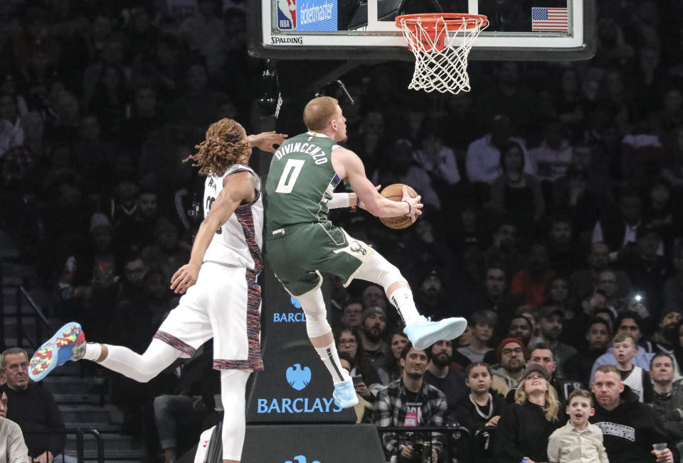 Milwaukee Bucks guard Donte DiVincenzo (0) drives past Brooklyn Nets forward Caris LeVert (22), during a NBA basketball game, Saturday Jan. 18, 2020 in New York. (AP Photo/Bebeto Matthews)