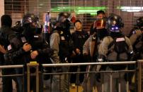 Police officers check IDs and order protesters to leave the area after an anti-government protest at Yoho Mall in Yuen Long