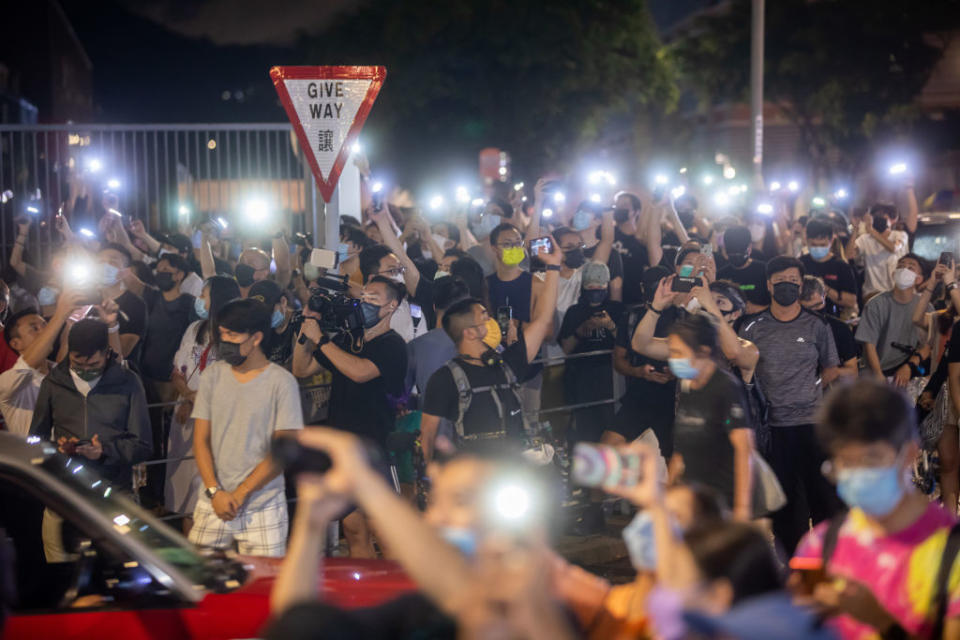 Supporters holding up mobile phone torches at the headquarters of the Apple Daily newspaper.