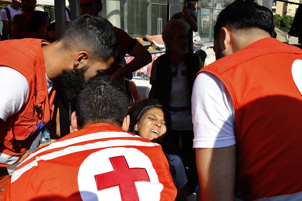 Lebanese Red Cross volunteers help an injured anti-government protester after riot police open a road in Beirut, Lebanon, Thursday, Oct. 31, 2019. Army units and riot police took down barriers and tents set up in the middle of highways and major intersections Thursday. (AP Photo/Bilal Hussein)