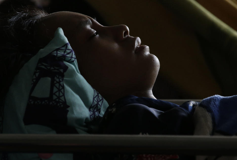 In this Thursday, Oct. 4, 2018, file photo, Anisa Cornelia grimaces in pain from injuries received in a massive earthquake and tsunami in Palu, Central Sulawesi, Indonesia. (AP Photo/Aaron Favila, File)