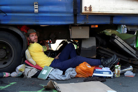 A climate change activist is glued on a truck during the Extinction Rebellion protest on Waterloo Bridge in London, Britain April 20, 2019. REUTERS/Simon Dawson