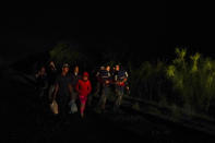 Emely, 8, of Honduras, center, walks with a group of migrants after turning themselves in upon crossing the U.S.-Mexico border Wednesday, May 12, 2021, in La Joya, Texas. Growing numbers of migrant families are making the heart-wrenching decision to separate from their children and send them into the U.S. alone. (AP Photo/Gregory Bull)