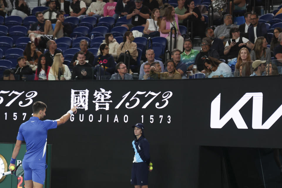 Novak Djokovic of Serbia points to a spectator during his second round match against Alexei Popyrin of Australia at the Australian Open tennis championships at Melbourne Park, Melbourne, Australia, Wednesday, Jan. 17, 2024. (AP Photo/Asanka Brendon Ratnayake)