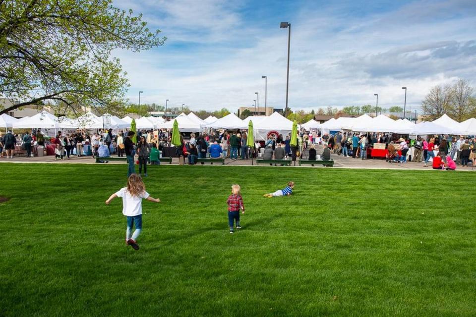 Kids play in the grass during the Boise Farmers Market at 1500 Shoreline Drive in 2022. Proposed developments could revamp the area along Americana Boulevard. Guy Hand