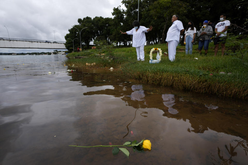 Followers of the Yoruba religion give offerings to Yemanja, a deity celebrated by the African Yoruba religion, at a lake in downtown Brasilia, Brazil on New Year’s Eve, Friday, Dec. 31, 2021. As the year winds down, Brazilian worshippers celebrate Yemanja, goddess of the sea, offering flowers and launching large and small boats into the water in exchange for blessings for the coming year. (AP Photo/Eraldo Peres)