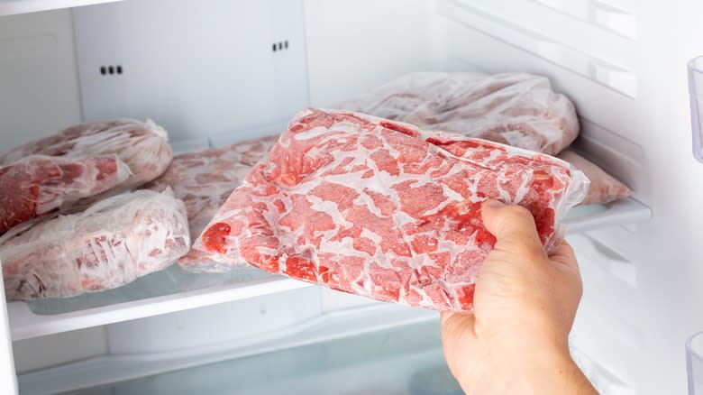 person taking meat from freezer