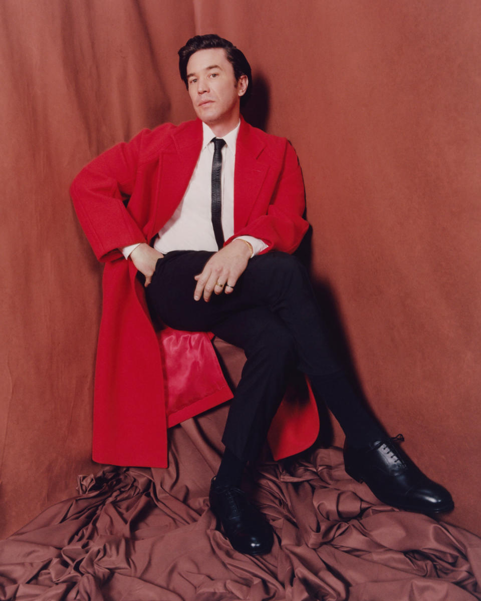 Closeup of Tom Pelphrey sitting on a chair in a coat for a photo shoot