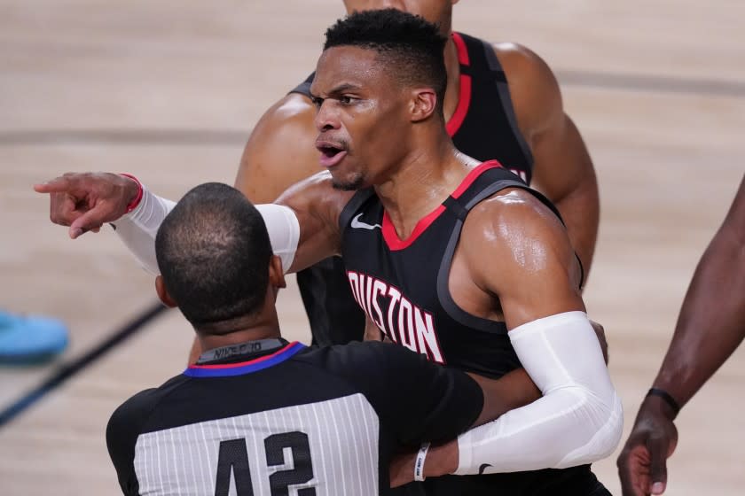 The Rockets' Russell Westbrook is held back by a referee as he argues during the second half Sept. 12, 2020.