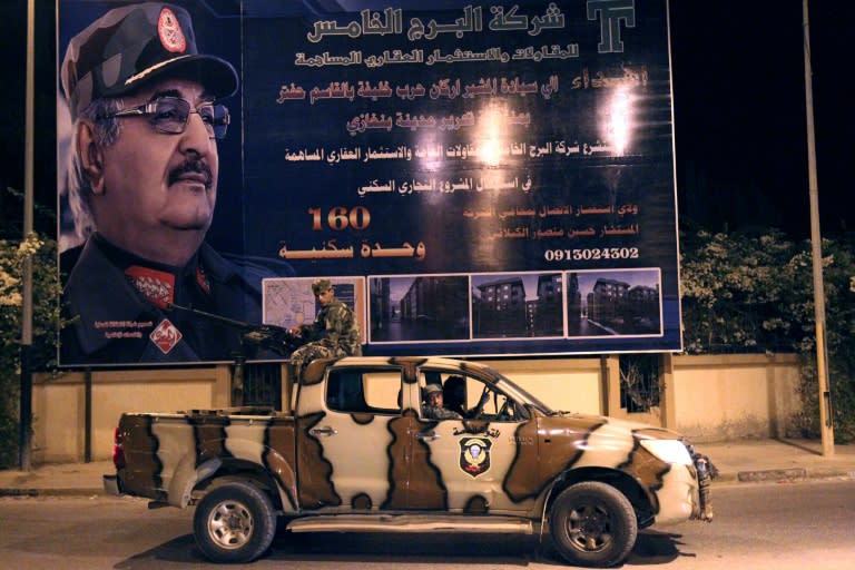 Forces loyal to Libyan military strongman Khalifa Haftar, pictured on a billboard, control much of the east and south of the country