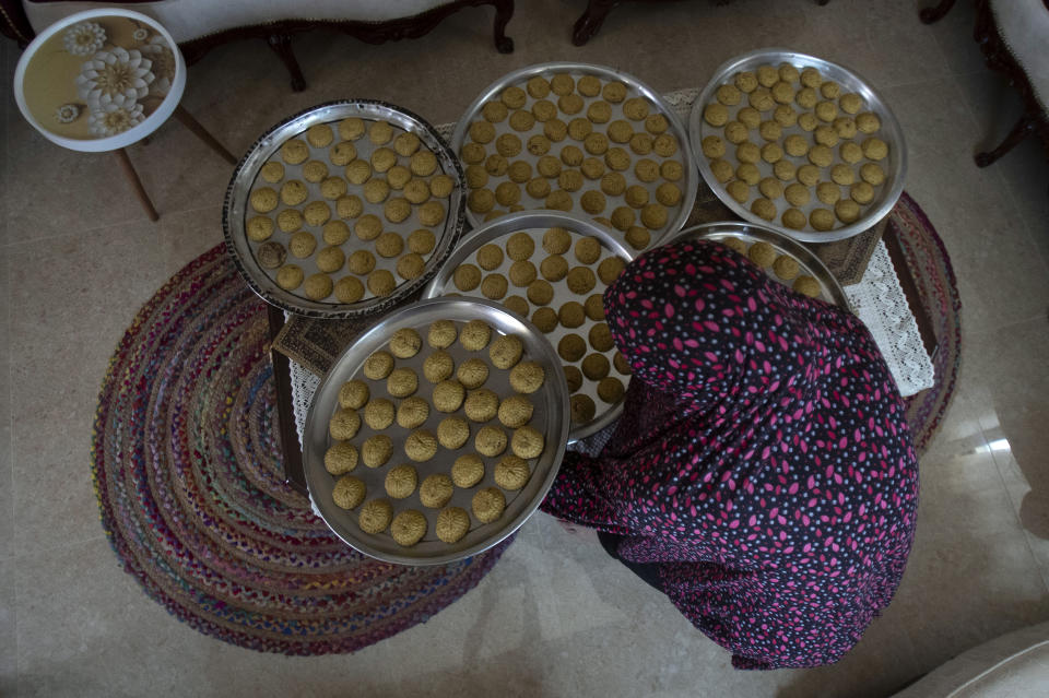 A Palestinian woman prepares sweets ahead of the Muslim Eid al-Adha holiday, in the West Bank city of Nablus, Monday, July. 19, 2021. Eid al-Adha, or Feast of Sacrifice, Islam's most important holiday marks the willingness of the Prophet Ibrahim (Abraham to Christians and Jews) to sacrifice his son, is to start on Tuesday with Muslims slaughtering animals and celebrating the end of their annual hajj pilgrimage to the holy city of Mecca in Saudi Arabia. (AP Photo/Majdi Mohammed)