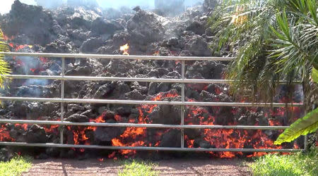 REFILE - ADDING RESTRICTIONS Lava advances towards a metal barrier in Puna, Hawaii, U.S., May 6, 2018 in this still image obtained from social media video. WXCHASING via REUTERS