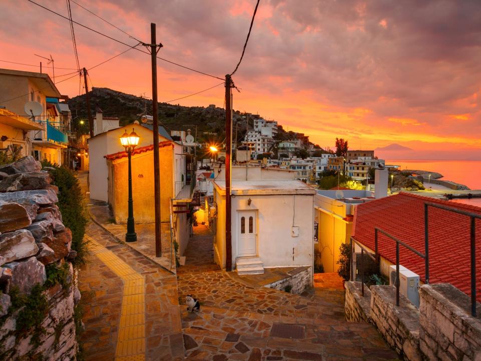 A path leading upward through a village at sunset.