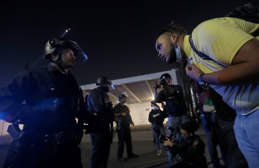 LOS ANGELES, CA - NOV. 3, 2020. A protester berates a police officer in downtown Los Angeles on election night, Tuesday, Nov. 3, 2020. (Luis Sinco / Los Angeles Times)