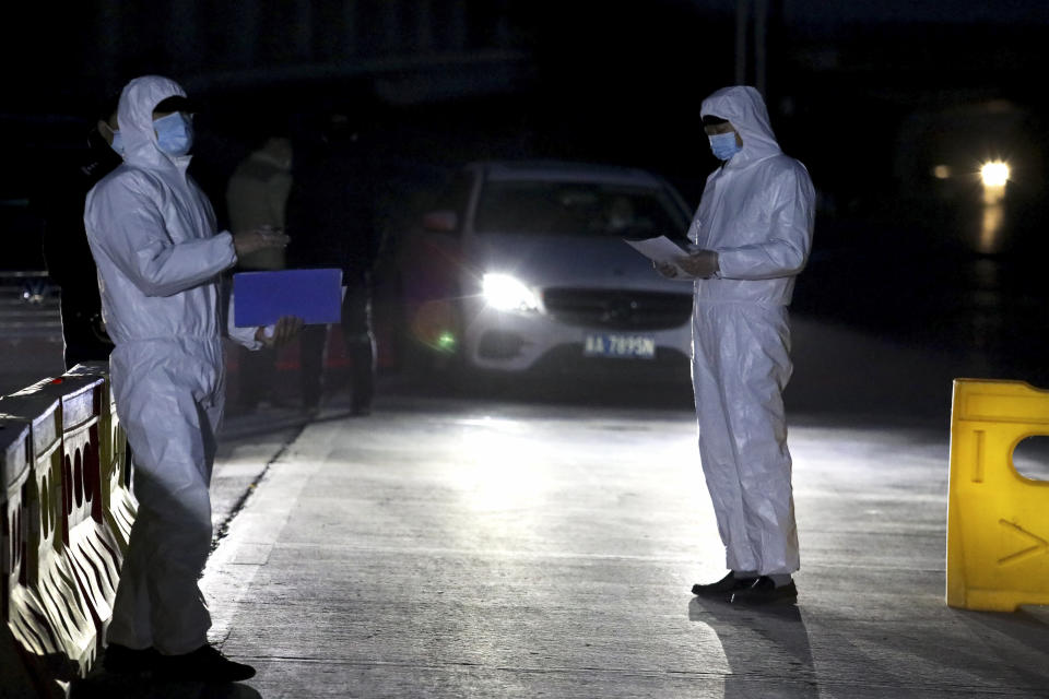 In this photo released by Xinhua News Agency, police officers in protective suits stand on duty at a temporary checkpoint in Shijiazhuang in northern China's Hebei Province on Saturday, Jan. 9, 2021. More than 360 people have tested positive in a growing COVID-19 outbreak south of Beijing in neighboring Hebei province. (Jin Haoyuan/Xinhua via AP)