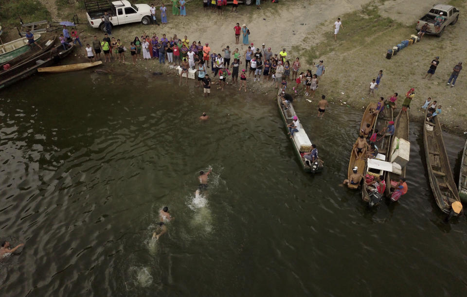 In this Nov. 25, 2018 photo, indigenous men finish the swimming competition during the second edition of the Panamanian indigenous games on lake Bayano, Panama. In terms of surface area, Lake Bayano is the second largest lake in Panama, exceeded only by Lake Gatun. (AP Photo/Arnulfo Franco)