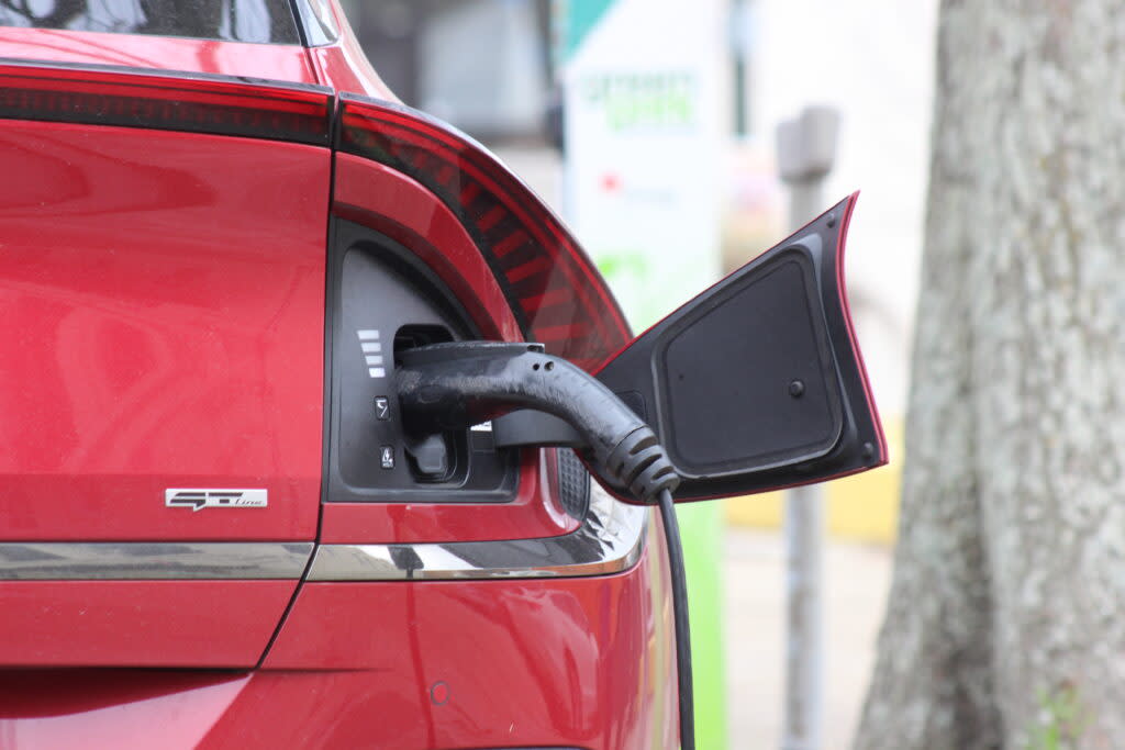 Close-up of electric car with charger plugged in