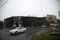 In this photo taken Monday, Nov. 18, 2019, and released by the Iranian Students' News Agency, ISNA, cars drive past a building which burned during protests that followed the authorities' decision to raise gasoline prices, in the city of Karaj, west of the capital Tehran, Iran. An article published Tuesday in Keyhan, a hard-line newspaper in Iran suggested that those who led violent protests will be executed by hanging as the unrest continues. (Masoume Aliakbar/ISNA via AP)