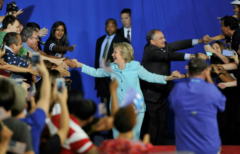 Democratic presidential candidate Hillary Clinton (L) and running mate Tim Kaine (R) arrive for a campaign rally in Miami on July 23, 2016