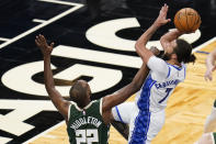 Milwaukee Bucks forward Khris Middleton (22) tries to stop Orlando Magic guard Michael Carter-Williams (7) as he takes a shot during the second half of an NBA basketball game, Sunday, April 11, 2021, in Orlando, Fla. (AP Photo/John Raoux)