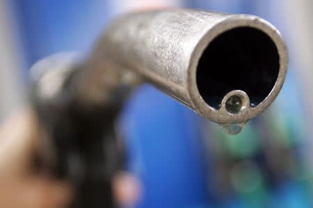 A motorist holds a fuel pump at a Gulf petrol station in London April 18, 2006. REUTERS/Luke MacGregor