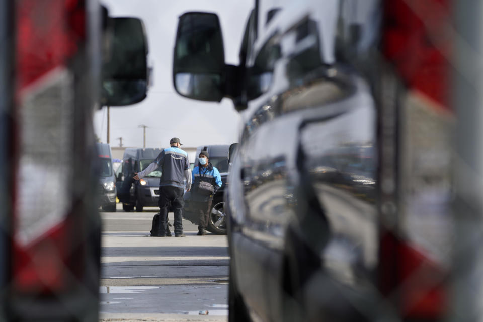 Amazon drivers wait next to their delivery vans for their logistics systems to be back online at the Amazon Delivery Station in Rosemead, Calif., Tuesday, Dec. 7, 2021. Amazon Web Services suffered a major outage Wednesday. The company provides cloud computing services to individuals, universities, governments and companies, including The Associated Press. (AP Photo/Damian Dovarganes)