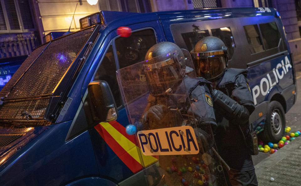 National police are hit by plastic balls thrown by demonstrators during a demonstration in Barcelona, Spain, Saturday, Oct. 26, 2019. Protests turned violent last week after Spain's Supreme Court convicted 12 separatist leaders of illegally promoting the wealthy Catalonia region's independence and sentenced nine of them to prison. (AP Photo/Emilio Morenatti)