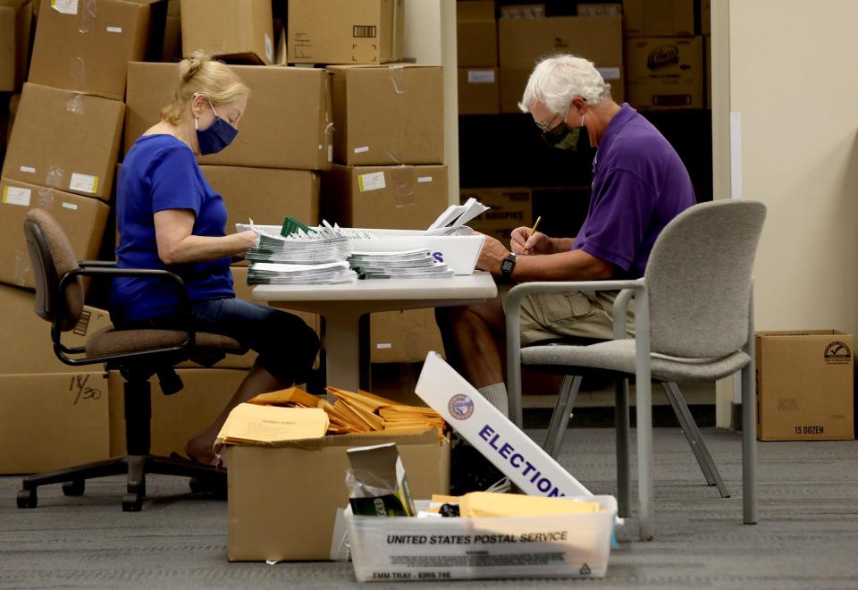 (L to R)  Elaine Edmonds  and Denis Strauch who has been volunteering at 9 elections for Elaine and 3 for Denis process absentee ballots before they are scanned and processed at a building at the Livonia City Hall complex in Livonia, Michigan on Tuesday, August 4, 2020 
The ballots would then be taken to high-speed scanners nearby that can accurately count up to 25 ballots at a time for a quicker counting process.
Over 300 volunteers are working with Livonia city clerk Susan Nash on Election Day.